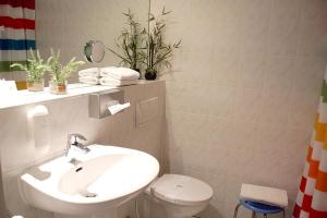ein Badezimmer mit einem weißen Waschbecken und einem WC in der Unterkunft Solitaire Hotel in Berlin