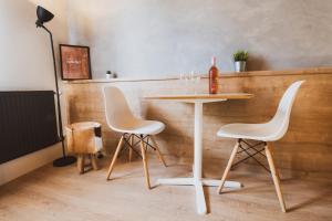 a table with two white chairs and a bottle of wine at Penzion Castello in Valtice