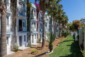 a row of palm trees in front of a building at Smart Stay Beach Bodrum -All Inclusive in Gümbet