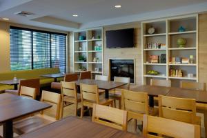 a restaurant with tables and chairs and a fireplace at Country Inn & Suites by Radisson, Frederick, MD in Frederick