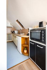 una piccola cucina con forno a microonde nero e lavandino di IDEAL PRO - 10min gare - Hypercentre - WIFI - Longuedurée a Pau