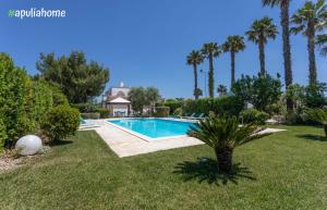 basen w ogrodzie z palmami w obiekcie Villa Pompea al piano terra - Apulia Home w mieście Casarano