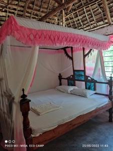 1 dormitorio con 1 cama con dosel en Mida Creek Eco Camp en Watamu