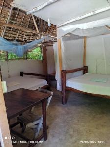 Habitación con 2 camas y mesa. en Mida Creek Eco Camp, en Watamu