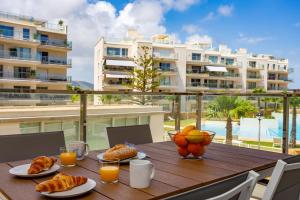 a table with food and orange juice on a balcony at Denia Apartment Marina Real in Denia