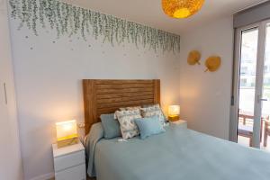 a bedroom with a bed with two lamps and a window at Denia Apartment Marina Real in Denia +50 photos