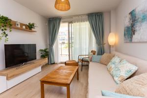 a living room with a couch and a tv at Denia Apartment Marina Real in Denia