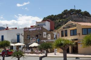 a group of buildings with umbrellas and palm trees at Denia Apartment Marina Real in Denia