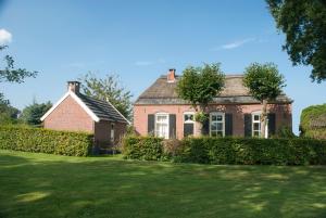 an old brick house with a green yard at De Bolderie in Markelo