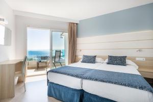 a hotel room with a bed and a view of the ocean at Tomir Portals Suites - Adults Only in Portals Nous