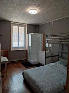sypialnia z łóżkiem piętrowym i lodówką w obiekcie L'HotenTyka w mieście Saint-Senoch