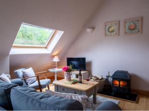 a living room with a couch and a fireplace at Amber Cottage in Little Witcombe