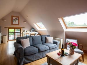 Little Witcombe的住宿－Amber Cottage，客厅配有蓝色的沙发和桌子