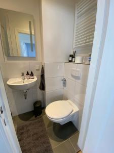 a white bathroom with a toilet and a sink at Schönes 2-Zimmer-Apartment in Bremen, Findorff in Bremen
