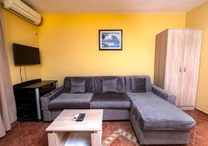 uma sala de estar com um sofá e uma mesa em APARTMANI VUKADINOVIC LUX em Budva