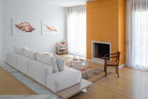 a living room with a white couch and a fireplace at Love White Villa in Ialysos
