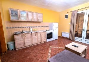 uma cozinha com paredes amarelas e um frigorífico branco em APARTMANI VUKADINOVIC LUX em Budva