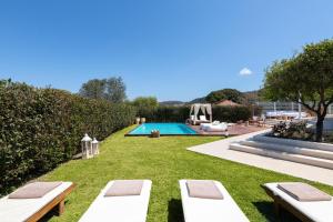 a backyard with a swimming pool and lawnitures at Love White Villa in Ialysos