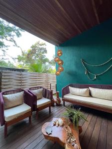 a patio with couches and a table and a green wall at Pousada Júlio Grande in Fernando de Noronha