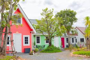 a row of houses with red white and green at บ้านสวนทิวภูผาวัดเจดีย์ไอ้ไข่ in Ban Sai Liang