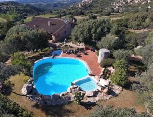 an overhead view of a swimming pool with rocks and a house at Sardinia Family Villas - Villa Elena with salt water private pool in Arzachena