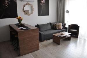 sala de estar con sofá y mesa en Q Apart GRAND - 3 Pokoje Manufaktura, garaż Netflix, klimatyzacja, FV,, en Łódź