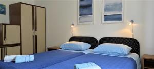 um quarto com uma cama azul e 2 almofadas em Apartments Ljilja sea view em Slatine