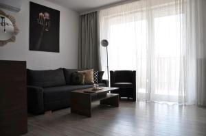 a living room with a couch and a coffee table at Q Apart GRAND - 3 Pokoje, garaż Netflix, klimatyzacja, FV, in Łódź
