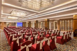 a banquet hall with red chairs and a chandelier at Lords Inn Jaipur in Jaipur