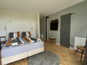 een slaapkamer met een bed en een woonkamer bij Stoomzicht in Wijlre