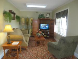 a living room with two couches and a tv at Honeysuckle Inn in Mountain View