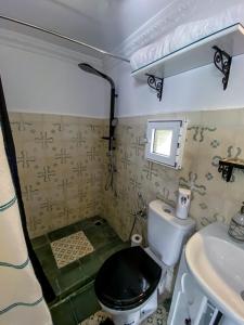 La petite salle de bains est pourvue de toilettes et d'un lavabo. dans l'établissement Dar Tinjâa, à Tanger