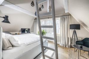 a bedroom with a loft bed with a ladder and a chair at Vila Čapek in Branžež