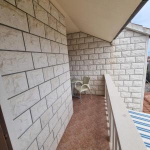 un patio con una pared de ladrillo blanco y una silla en Villa Mila, en Bol
