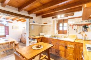 a kitchen with wooden cabinets and a wooden table at Finca Sta Teresa, Casa Grande in Estepona