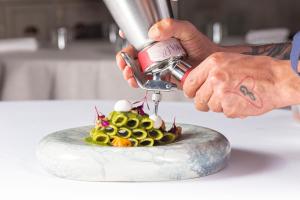 a person cutting a cake with a mixer on a counter at Tenuta C'est la Vie in Ischia