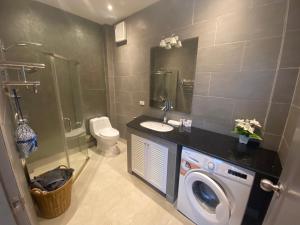 a bathroom with a washing machine and a sink at Relax and Rejuvenate in Rayong! in Rayong
