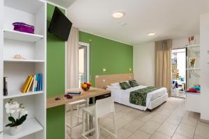 una camera con letto e scrivania con scrivania di Rubino Apartments a 100metri dal mare a Riccione