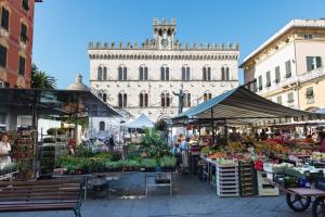 an outdoor market with a large building in the background at Piccolo Borgo in Chiavari