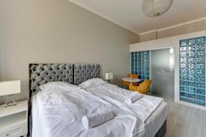 a bedroom with a large bed with white sheets and pillows at La Casa del Grand Apartments Sopot in Sopot