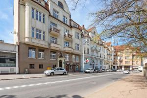 a city street with cars parked in front of buildings at La Casa del Grand Apartments Sopot in Sopot