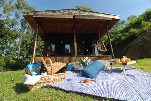 a gazebo with a picnic table and chairs in the grass at Cabana em meio a natureza com piscina. in Rodeio
