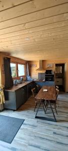 a kitchen with a table and chairs in a cabin at Cahute de montagne pour profiter du Haut Jura in Prémanon