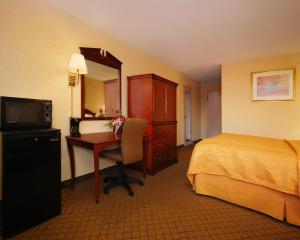 a hotel room with a bed and a desk with a computer at Quality Inn Shenandoah Valley in New Market