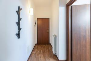 pasillo con puerta y suelo de madera en Alessia's Flat - Affori, en Milán
