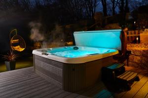a hot tub sitting on a deck with a chair at Popular with families - Cinder Hill in Whitby