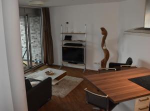a living room with a dining room table and a television at NewPort Weser, NewPort Marina in Bremerhaven