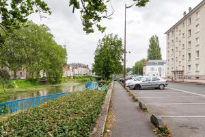 ブールジュにあるAppart T3 Bien situé a Bourges + Wifiの川のそばに車が駐車されている通り +3枚の写真