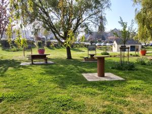 a park with three picnic tables and a tree at Loftdisa in Saint-Pair-sur-Mer