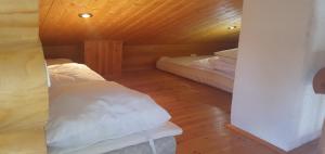 sypialnia z 2 łóżkami i drewnianym sufitem w obiekcie Järvenrantamökki Himoksella poreammeella w mieście Jämsä